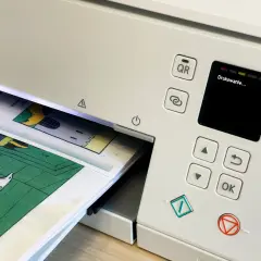 Drukarka drukuje komiks. Dowiedz się, jak wydrukować broszurę dwustronnie, by zaoszczędzić papier.