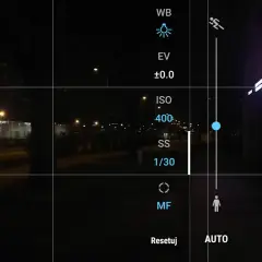 Ekran telefonu z widokiem nocnym. Ustawienia aparatu pokazują, jak ustawić długie naświetlanie, z widocznym ISO 400 i czasem 1/30s.