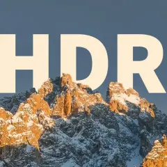 Góry w świetle zachodzącego słońca, pokryte śniegiem, z napisem HDR.