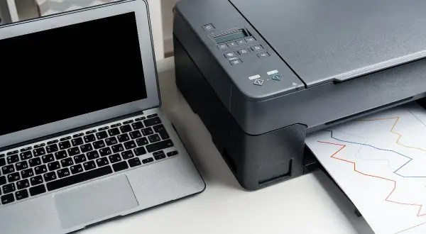 Jak połączyć drukarkę Epson z telefonem? Laptop i drukarka Epson drukująca wykresy.