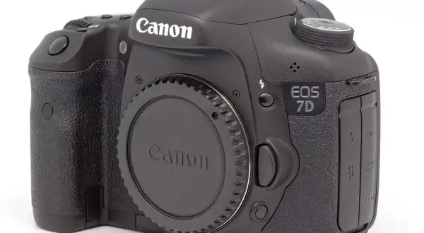 Czarny aparat Canon EOS 7D. Zastanawiasz się dslr co to? To właśnie taki aparat, z wymiennym obiektywem i lustrem.