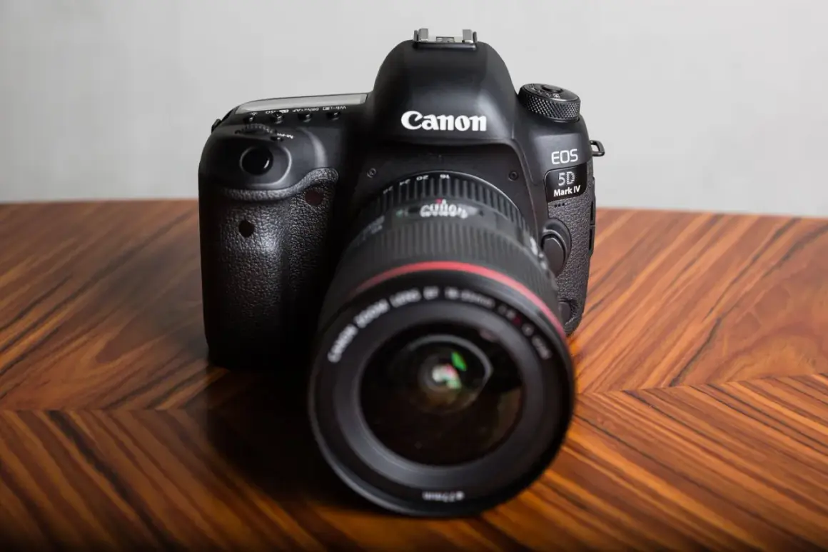 Profesjonalny aparat Canon EOS 5D Mark IV na drewnianym stole. Dowiedz się, jak sprawdzić przebieg migawki Canon.