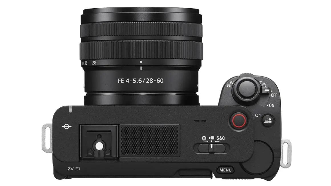 Czarny aparat Sony ZV-E1 z obiektywem FE 4-5.6/28-60. Widok z góry, z uchwytem na pasek i przyciskami sterującymi.