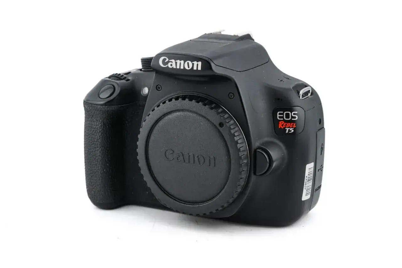 Czarny aparat Canon EOS Rebel T5 (znany też jako Canon 1200D) z zaślepką na obiektyw.